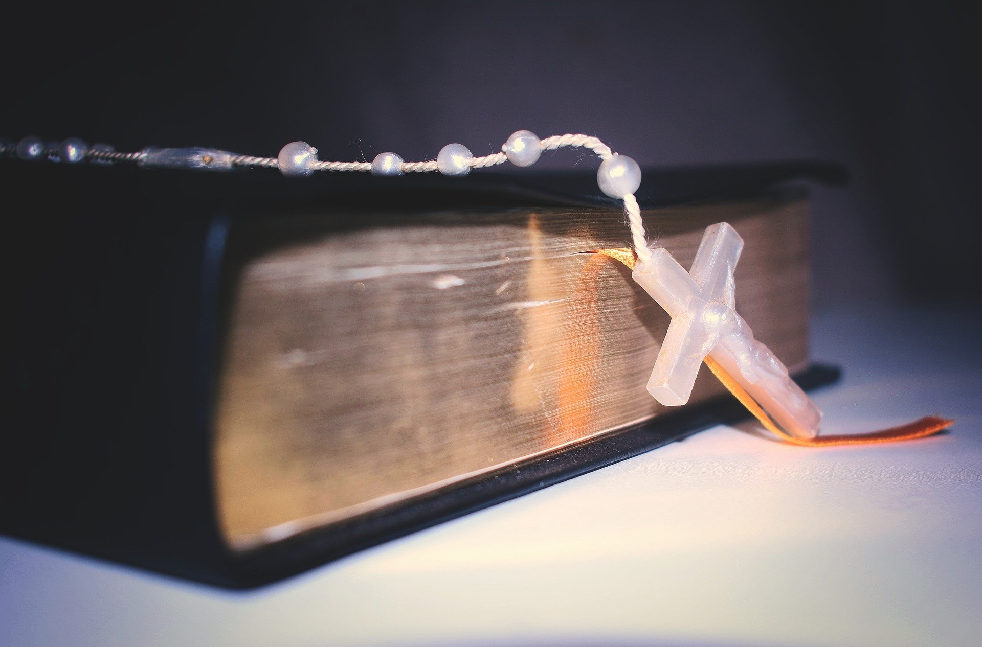 Holy Bible with Rosary draped across it